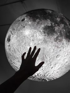 The silhouette for a hand against Luke Jerram's Moon inflatable